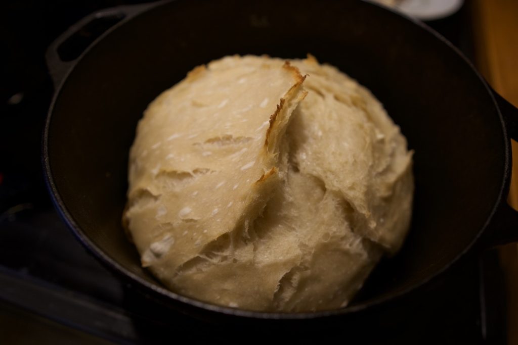 sourdough loaf just uncovered in cast iron dutch oven before baking uncovered to brown on top