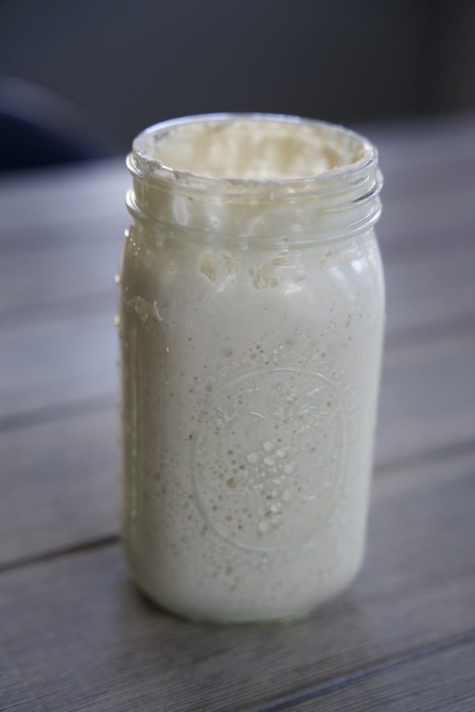 fed sourdough starter active and bubbly in quart size mason jar