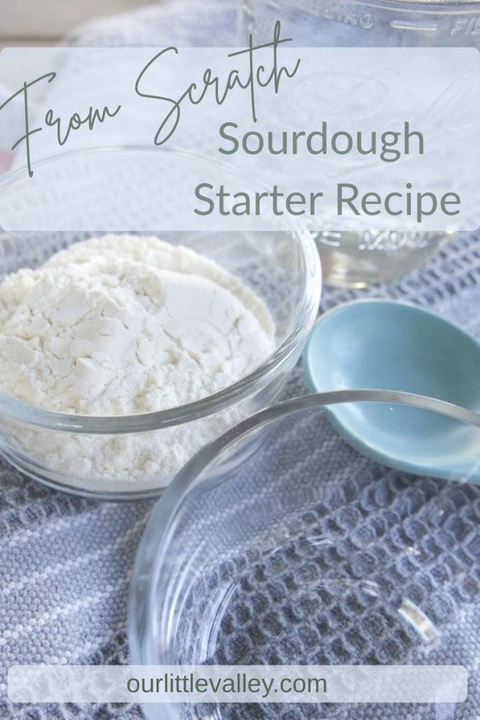 Ingredients on a table with a grey tea cloth. Flour in a small glass bowl, water in a small glass bowl, large measuring spoon. Simple sourdough starter recipe