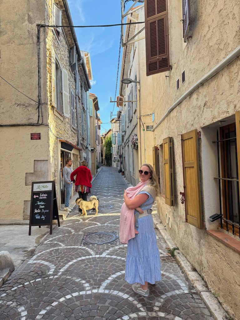 woman carrying child strolling street in antibes france