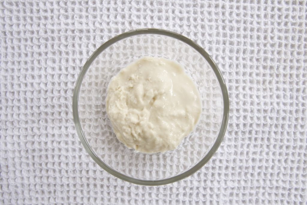 small glass bowl on white tea towel flour and water mixture on day 7 moved to clean bowl for simple sourdough starter recipe.