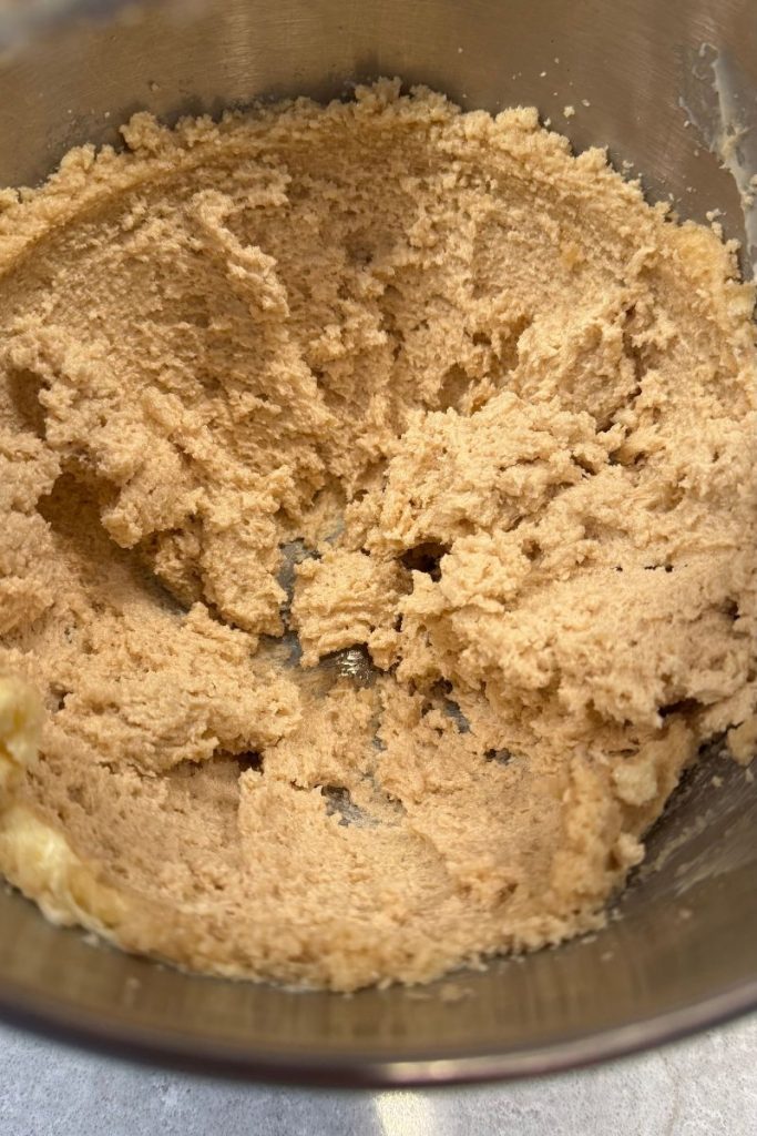 whipped butter and sugars for oatmeal chocolate chip cookie dough recipe in silver kitchen aid mixer bowl
